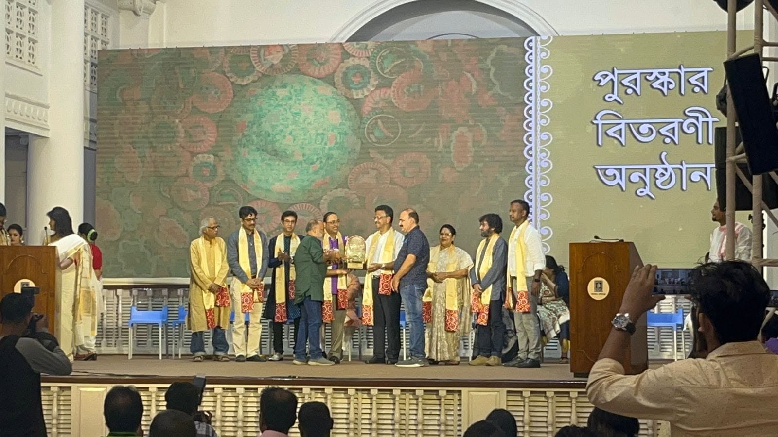 Formal group photo of organisers wearing saffron ceremonial shawls