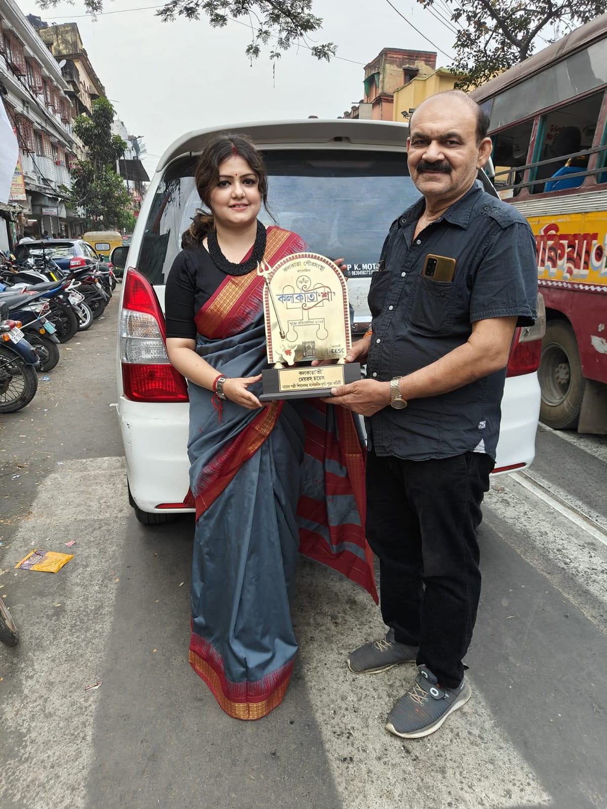 Committee members holding the Kolkata Municipal Corporation Mayor's Choice Durga Puja award trophy